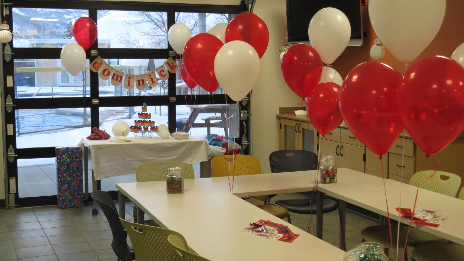 A room decorated for a birthday party with balloons and banners